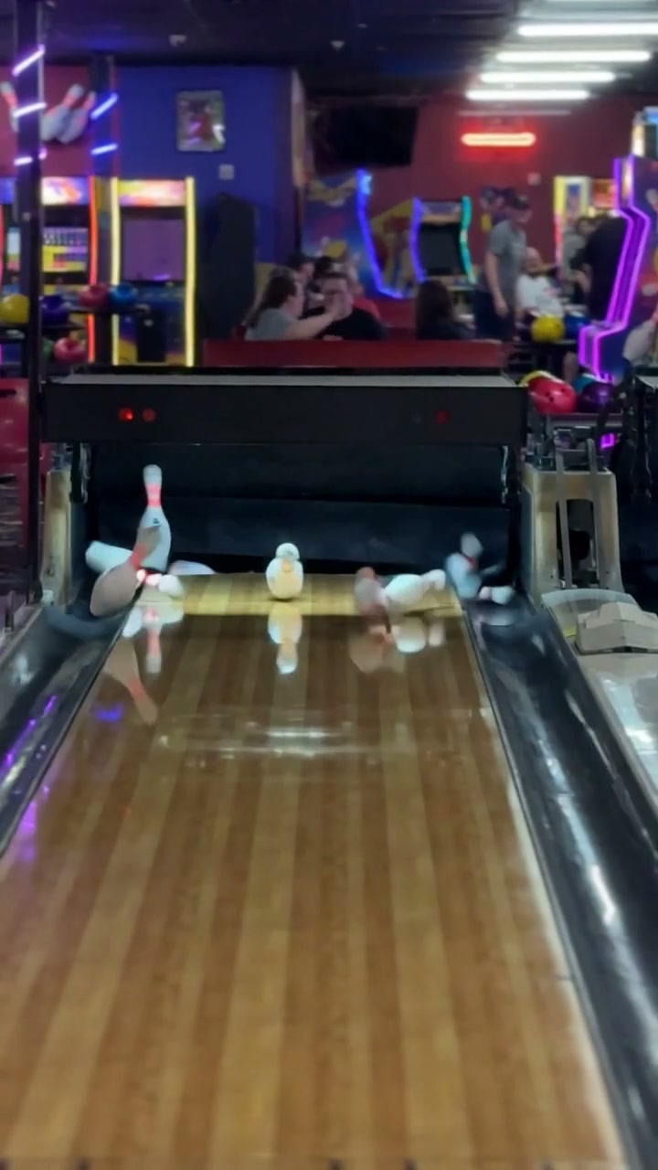 Bowling ball rolling toward a full rack of pins